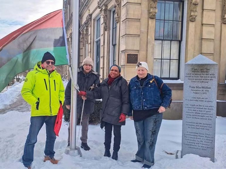 Angela Grogan and others raise the Pan-Africian Flag in Cobourg to mark Black History Month. Photo courtesy of The Town of Cobourg Facebook.
